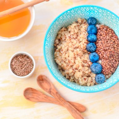 Sağlıklı kahvaltı malzemeleri. Beyaz ahşap arka plan üzerine karabuğday yaban mersini nane bal, üst görünüm, kopya alanı