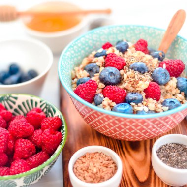 Yüksek proteinli sağlıklı kahvaltı, yaban mersinli karabuğday lapası, ahududu, keten tohumu ve bal.