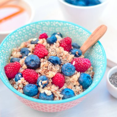 Yüksek proteinli sağlıklı kahvaltı, yaban mersinli karabuğday lapası, ahududu, keten tohumu ve bal.