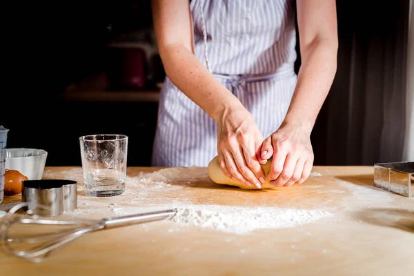 Женские руки месить тесто на столе, кухонные принадлежности — стоковое фото