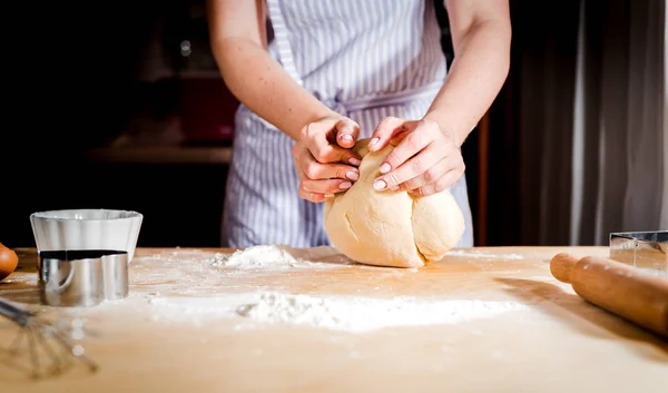 Facendo la pasta da mani femminili su tavolo di legno — Foto Stock