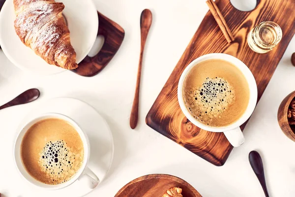 Desayuno europeo, café de canela croissant, nueces, rekan, almendras, miel, cuchara, madera, vista superior, buenos días, concepto de despertar, buenos días. Vista superior . — Foto de Stock