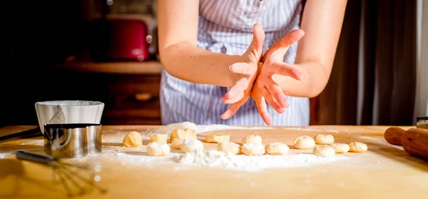 Жіночі руки замішують тісто на столі, кухонні аксесуари — стокове фото