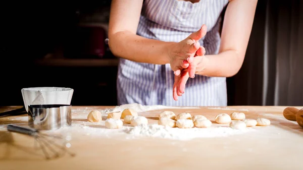 Жіночі руки замішують тісто на столі, кухонні аксесуари — стокове фото