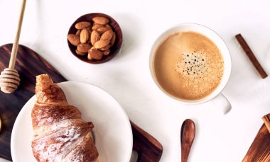 Ahşap masada kahve ve kruvasan içeren kahvaltı, üst görünüm