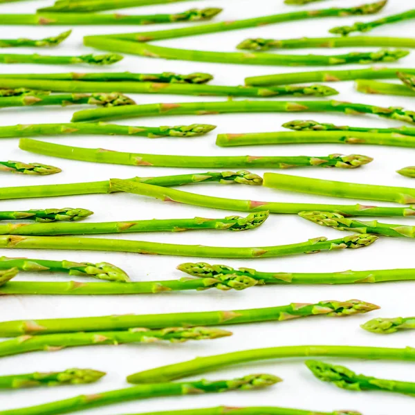 Patrón de brotes de espárragos verdes frescos, vista superior. Aislado sobre blanco. Fondo alimenticio espárragos patrón de puesta plana — Foto de Stock