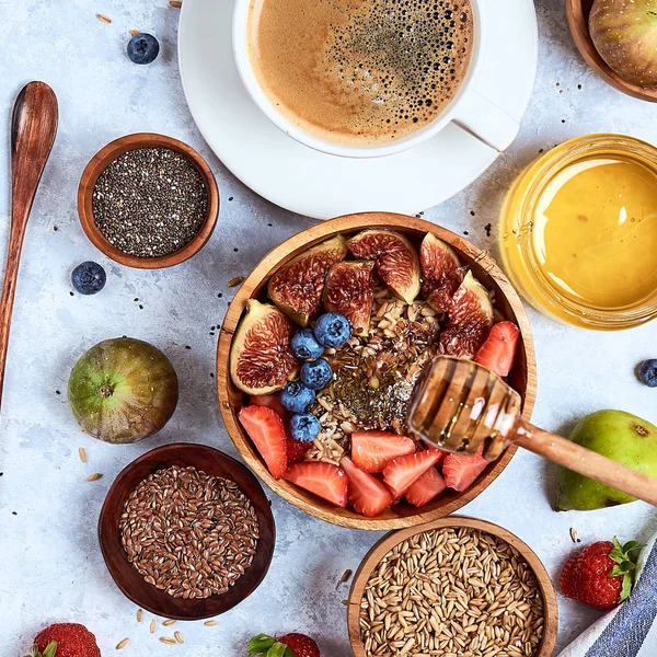 Здоровый завтрак и завтрак ингредиенты, овсянка с фруктами и ягодами, инжир, черника, клубника, семена льна и чиа, мед. Вид сверху, плоский — стоковое фото