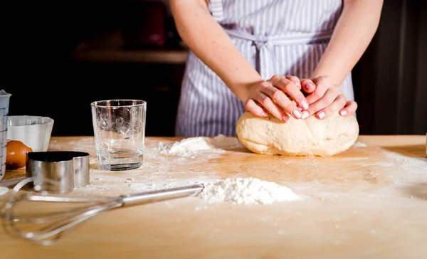 Le mani delle donne impastare l'impasto sul tavolo, accessori cucina — Foto Stock