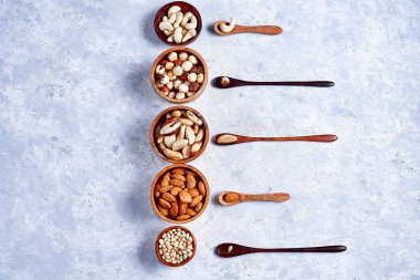 pekan, fındık, badem, çam fıstığı, Brezilya fıstığı, mavi arka plan üzerinde ahşap kase kaju fıstığı, üst görünümü, düz yatıyordu