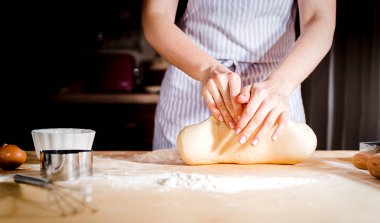 Ahşap masa üzerinde hamur yapma eller