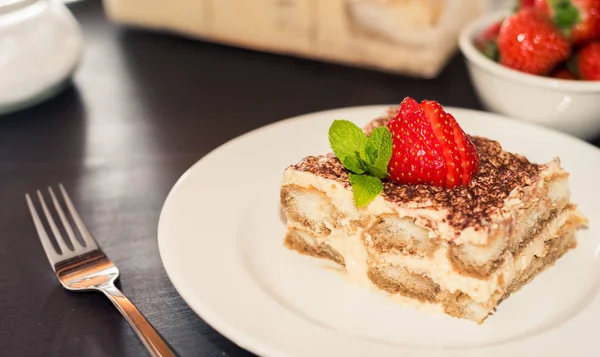 Gourmet-Tiramisu-Dessert mit Erdbeeren in einem schönen Teller auf dunklem Hintergrund — Stockfoto