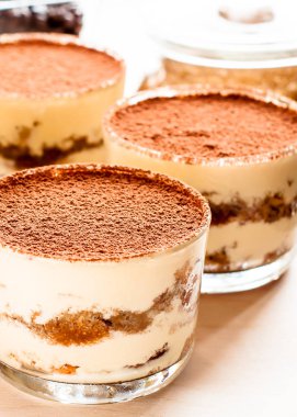 Camdaki tiramisu, ahşap arka plandaki nane şekeriyle süslenmiş.
