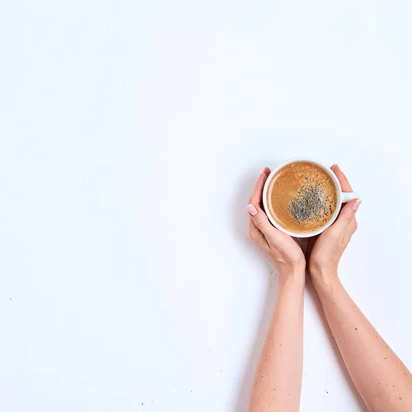 Біла чашка кави в жіночих руках на білому тлі. Вид зверху — стокове фото