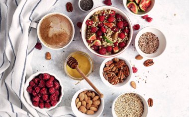 Sağlıklı bir kahvaltı için Malzemeler, ahududu ile yulaf ezmesi, incir, pekan, badem, keten tohumu, bal ve kahve ile chia tohumu. Günaydın, sağlık konsepti. Üstte görüntü