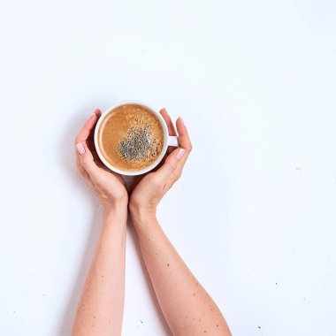 Beyaz bir arka plan üzerinde kadın elinde beyaz kahve fincanı. Üstte görüntü