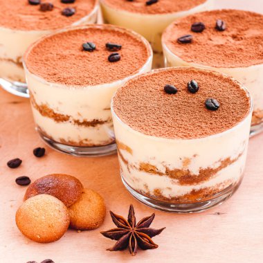 Camdaki tiramisu, ahşap arka plandaki nane şekeriyle süslenmiş.