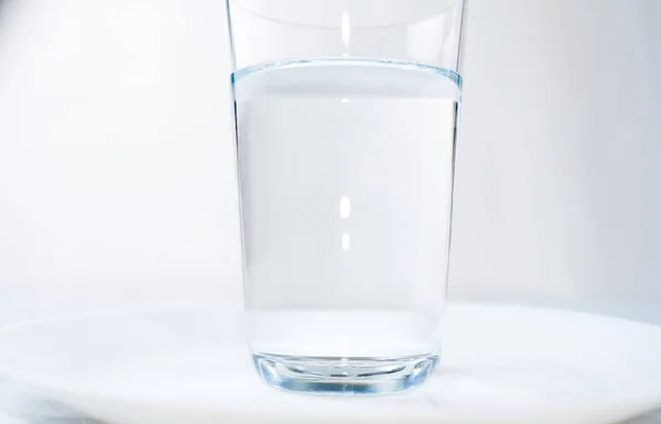 Vidrio de agua aislado sobre un fondo azul — Foto de Stock