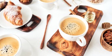 Ahşap masada kahve ve kruvasan içeren kahvaltı, üst görünüm