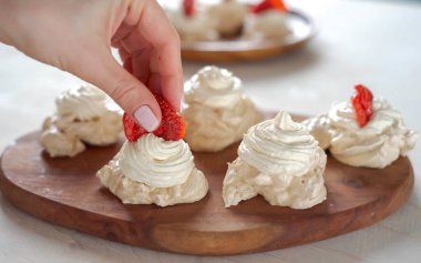 Kremayı çilekle süslüyorsun.