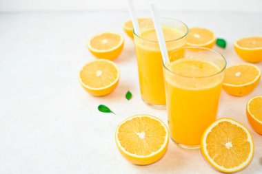 Taze portakal suyu ve portakallar kesim tahtasının üzerinde.