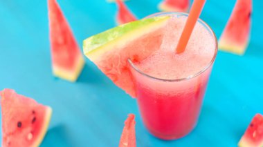 Mavi arka planda pipetli karpuz suyu