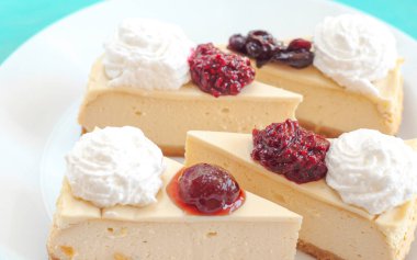 Kremalı beyaz tabakta reçelli cheesecake.