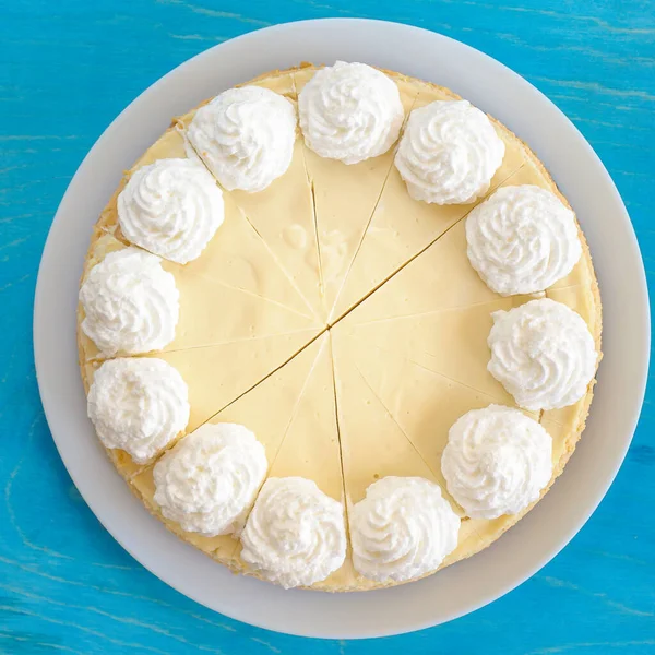 Pastel de queso clásico en un plato blanco, decorado con crema, vista superior — Foto de Stock