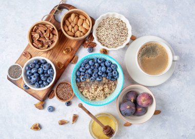 Sağlıklı bir kahvaltı için gerekenler, yabanmersinli kinoa, incir, bal ve fındıklı. Vejetaryen ve sağlıklı beslenmeyi düşün. Üst görünüm