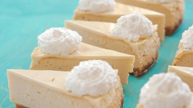 Cheesecake desenli, mavi arka planda cheesecake servis ediliyor.