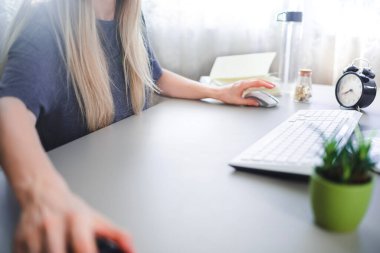 Genç kız evden bilgisayarın başında çalışıyor.