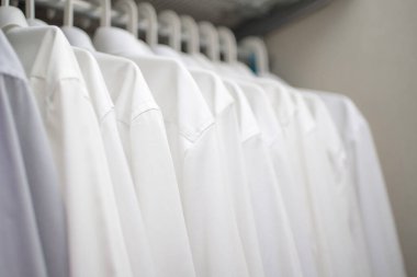 Beyaz adamların gömlekleri dolaptaki omuzlarda.