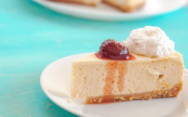 Beyaz tabakta reçelli cheesecake.