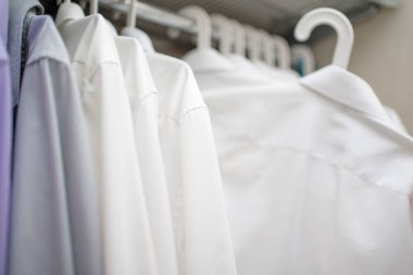 Beyaz adamların gömlekleri dolaptaki omuzlarda.