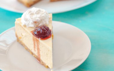 Beyaz tabakta reçelli cheesecake.