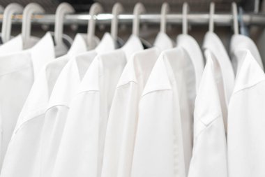 Beyaz adamların gömlekleri dolaptaki omuzlarda.