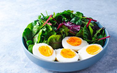 Mavi arka planda mavi bir kasede salata.