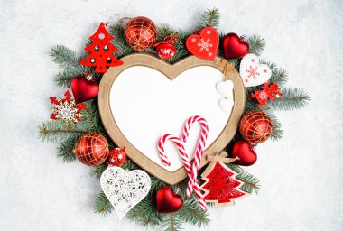 Kalp şeklinde bir Noel çerçevesi, fotokopi alanı olan yeni yıl ağacı süslemeleriyle çevrilidir. Üst manzara, düz uzanma.