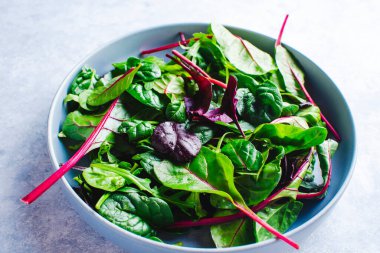 Mavi bir kasede taze salata yaprakları.