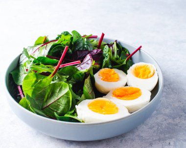 Mavi arka planda mavi bir kasede salata.