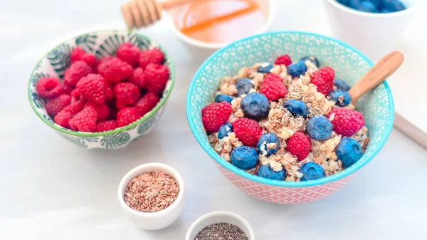 High protein healthy breakfast, buckwheat porridge with blueberries, raspberries, flax seeds and honey Closeup view, selective focus