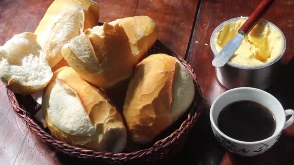 コーヒーカップを手に取り フランスパン のバスケットとテーブルの上で 伝統的なブラジルパン — ストック動画