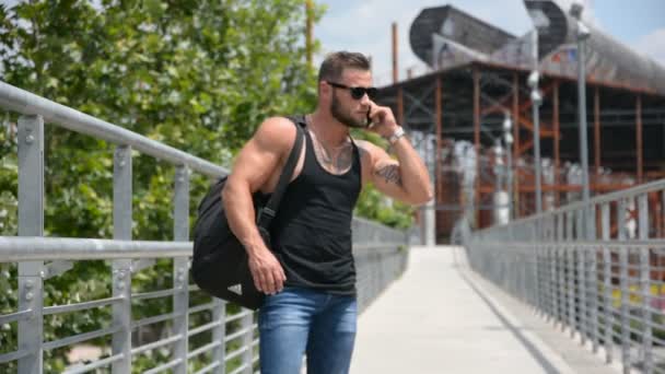 Attraente muscleman utilizzando il telefono cellulare — Video Stock