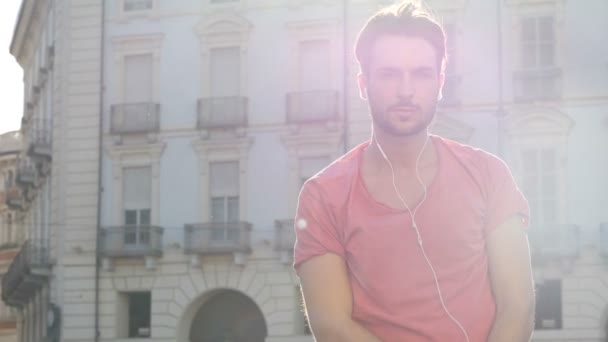 Молодой человек слушает музыку с наушниками — стоковое видео