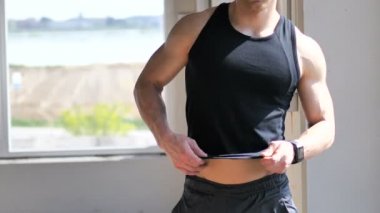 Genç adam çıplak kas gövde üzerinde gömlek üzerine koyarak yerleştirmek