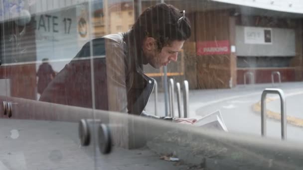 Hombre casual leyendo libro en el banco — Vídeos de Stock