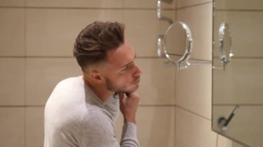 Elektrikli tıraş makinesi kullanarak çekici genç adam