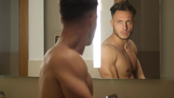 Без рубашки мускулистый красивый молодой человек в ванной комнате — стоковое видео