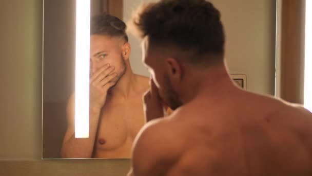 Shirtless gespierd knappe jonge man in de badkamer — Stockvideo