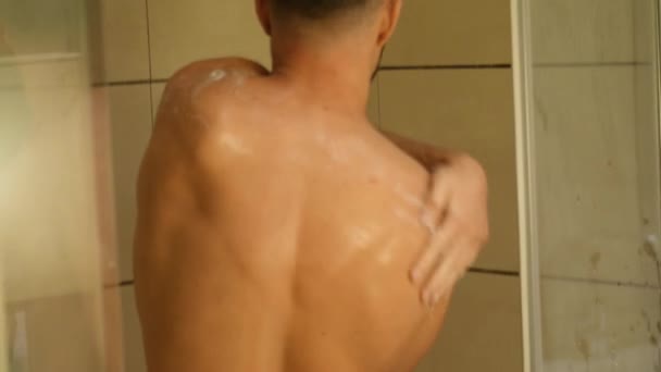 Привлекательный молодой спортсмен принимает душ дома — стоковое видео