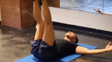 Paspas üzerinde karın kası egzersizi yapan yakışıklı genç adam.